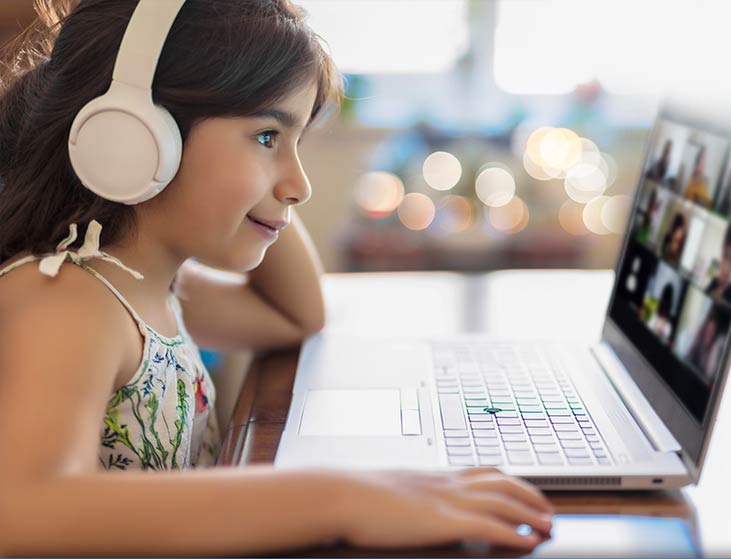 A young daughter does school lessons on a laptop using Aristotle High Speed Internet