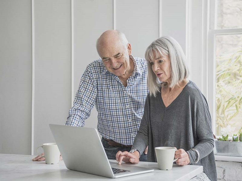 Senior husband and wife enjoy Aristotle High Speed Internet Wi-Fi on a laptop computer